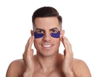 Man applying blue under eye patch on white background