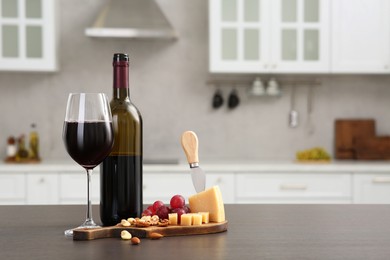 Red wine with fruits and, nuts, grape and cheese on countertop in kitchen, space for text