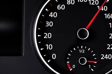 Speedometer with fuel gauge on car dashboard, closeup