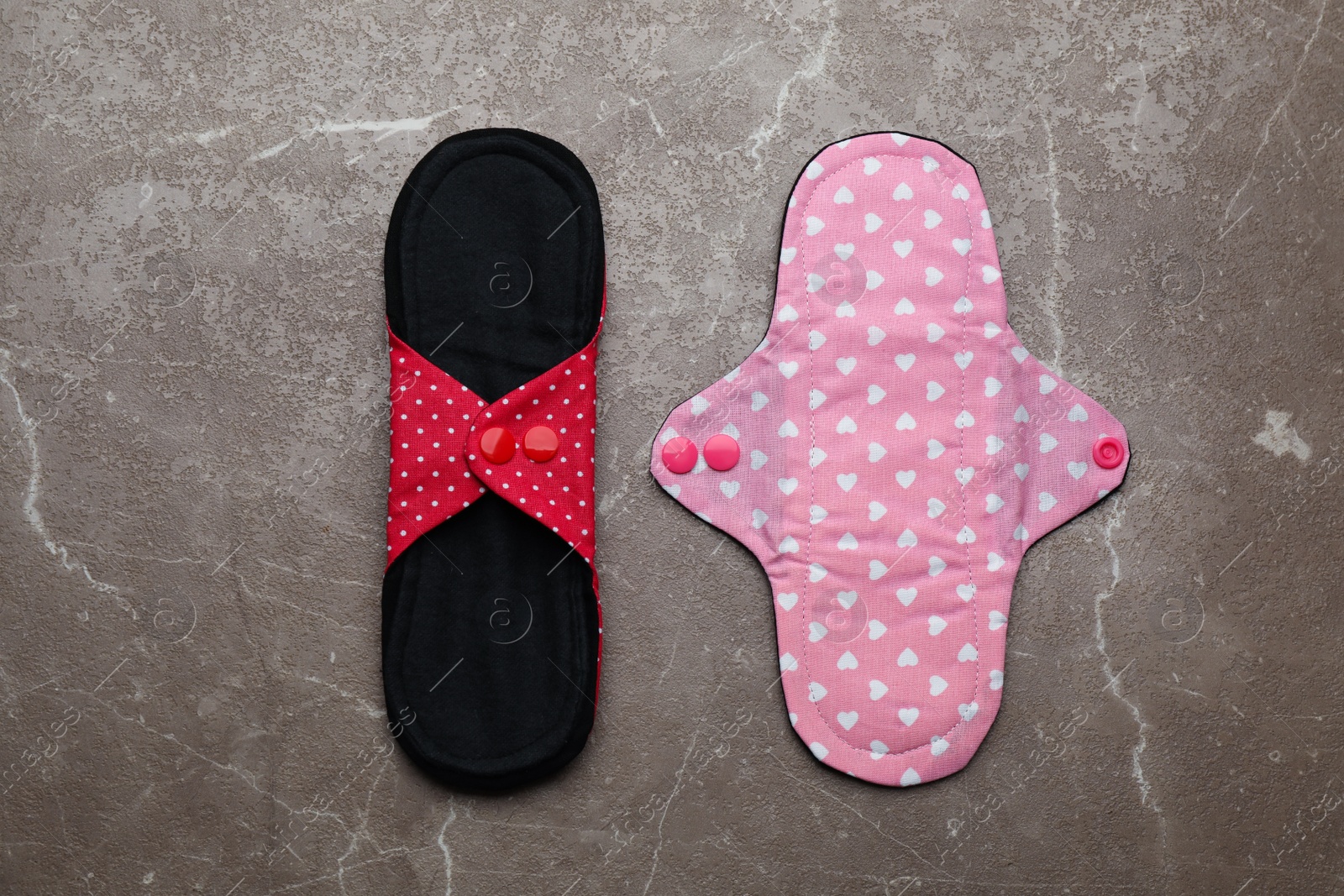 Photo of Reusable cloth menstrual pads on brown table, flat lay