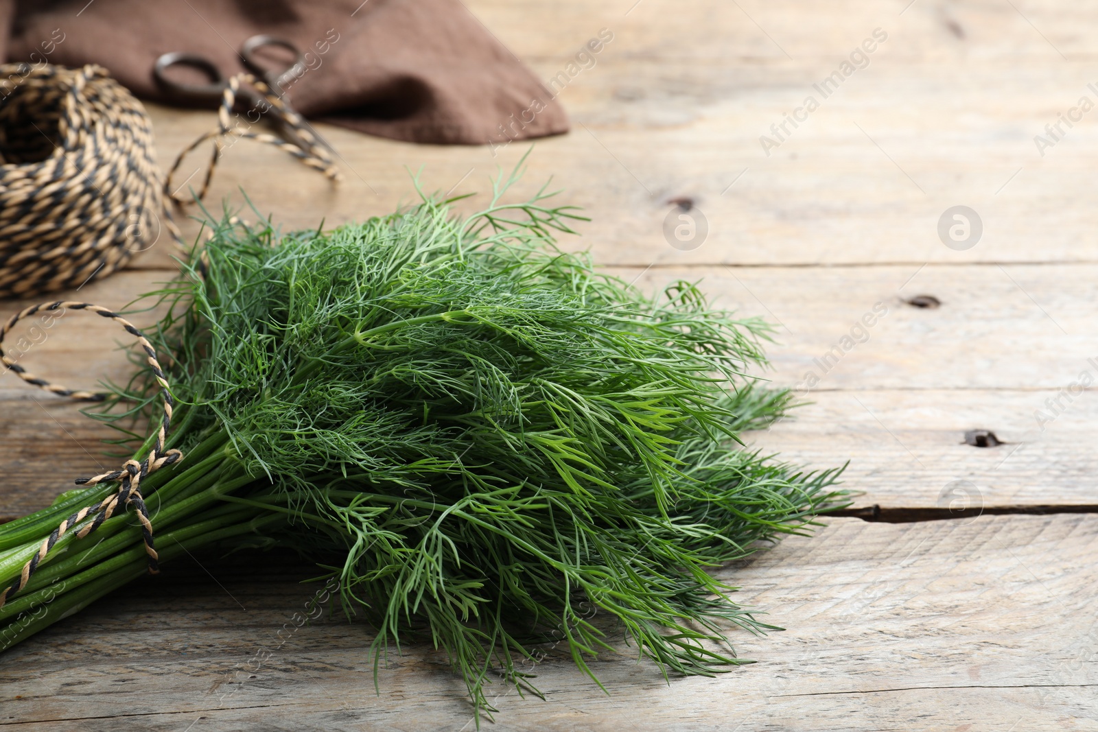 Photo of Bunch of fresh dill on wooden table, space for text