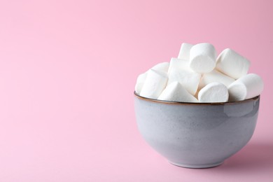 Photo of Delicious puffy marshmallows on pink background. Space for text