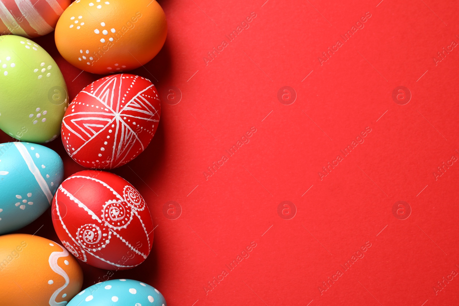 Photo of Flat lay composition of painted Easter eggs on color background, space for text