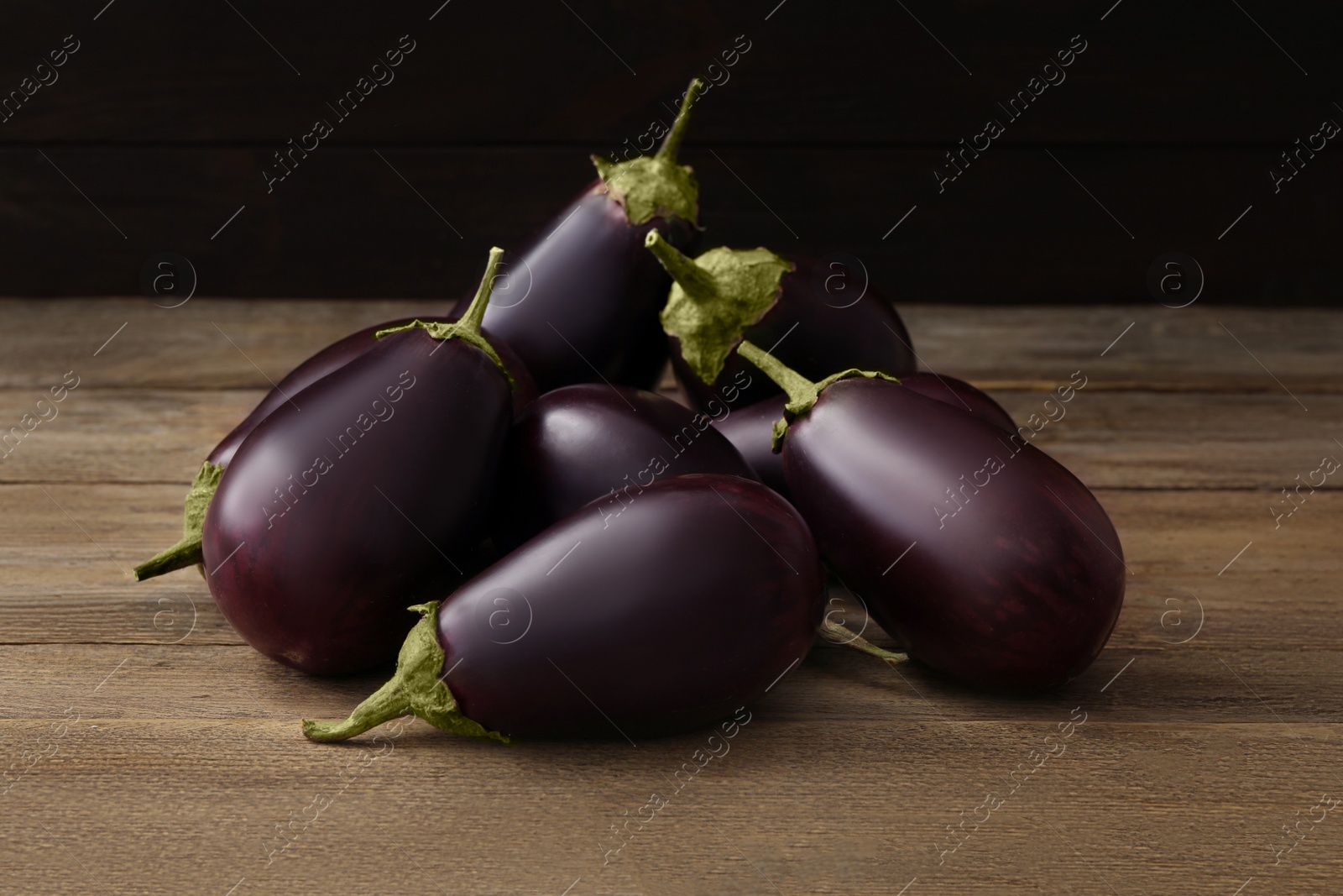Photo of Many raw ripe eggplants on wooden table