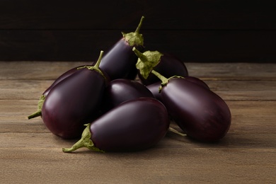 Photo of Many raw ripe eggplants on wooden table