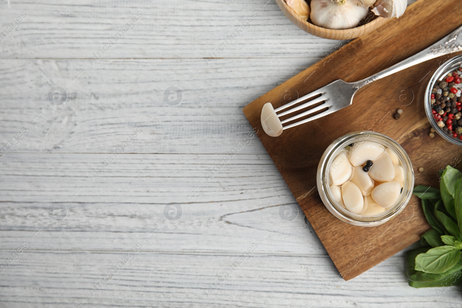 Photo of Flat lay composition with jar of pickled garlic on white wooden table. Space for text