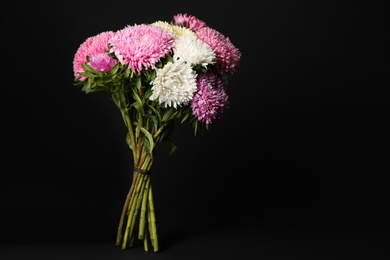 Photo of Bouquet of beautiful asters on black background, space for text. Autumn flowers
