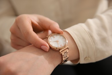 Woman in casual shirt with luxury wristwatch, closeup