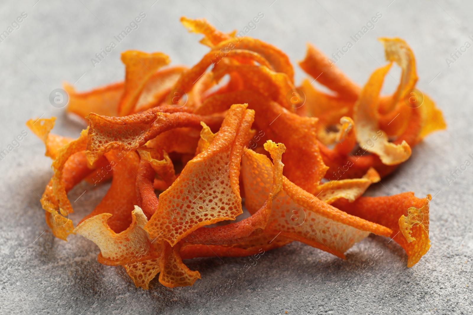 Photo of Dry orange peels on light gray textured table, closeup