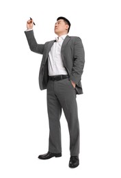 Photo of Businessman in suit with marker writing on white background, low angle view