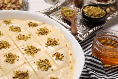 Photo of Making delicious baklava. Raw dough with ingredients on table, closeup