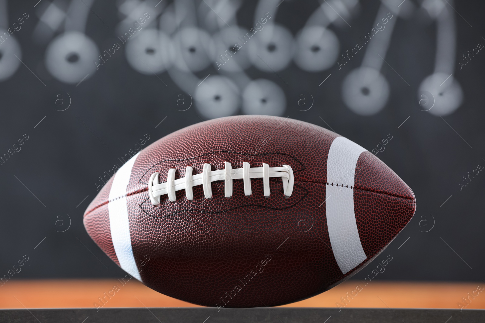 Photo of American football ball against blurred game scheme