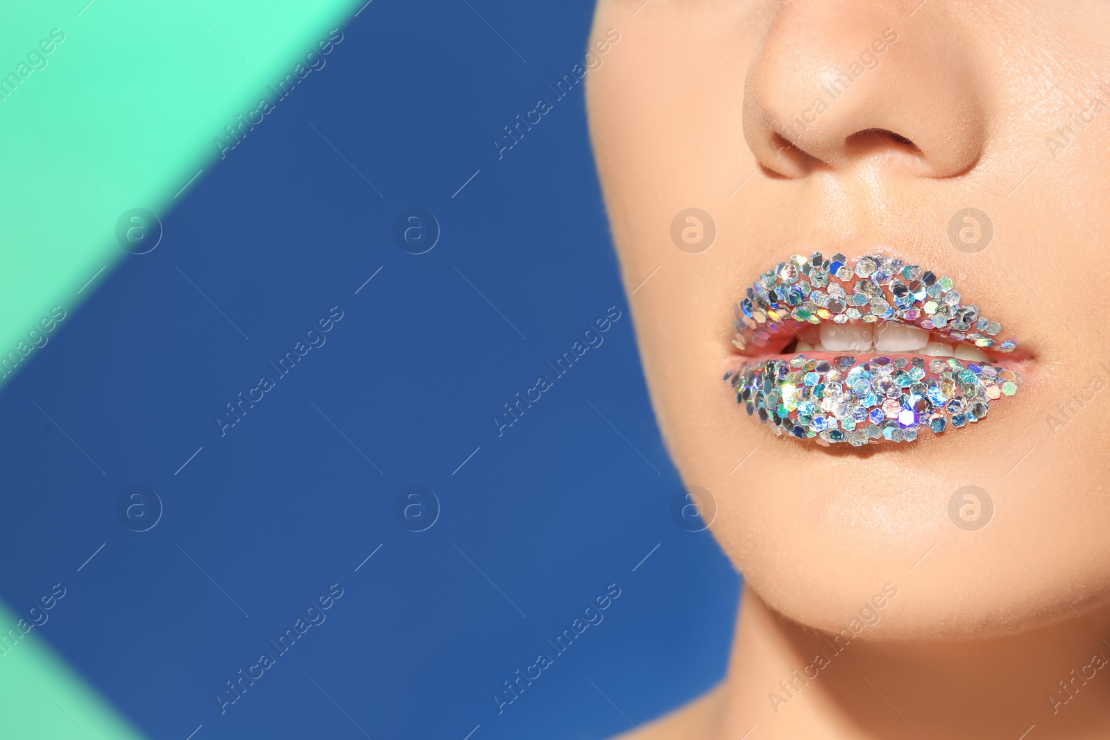 Photo of Beautiful young model with extravagant lips makeup on color background