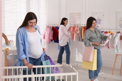 Happy pregnant women with shopping bags in store