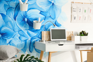 Photo of Stylish living room interior with blue flowers painted on wall. Floral pattern