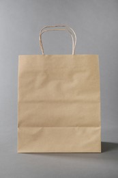 Photo of One kraft paper bag on grey background. Mockup for design