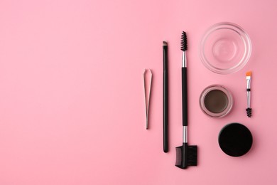 Eyebrow pomade with henna effect and professional tools on pink background, flat lay. Space for text