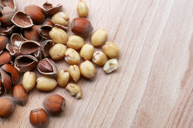 Tasty hazelnuts on wooden table, flat lay. Space for text