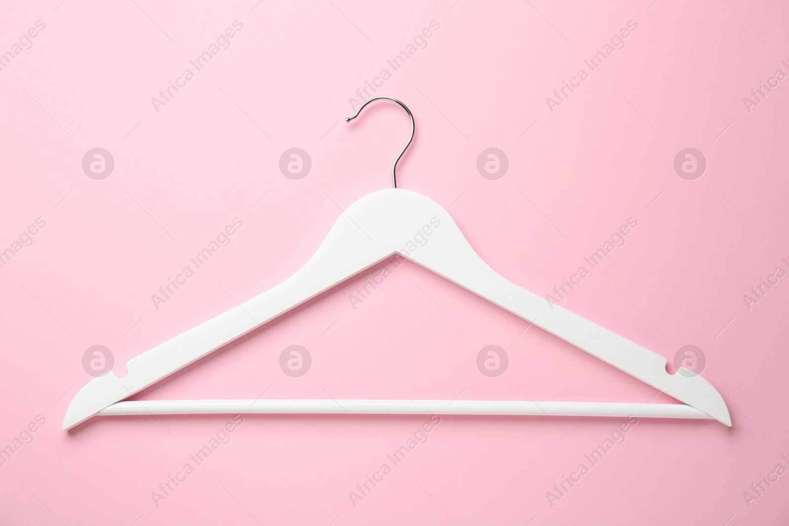 Photo of White hanger on pink background, top view