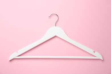 Photo of White hanger on pink background, top view