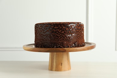 Photo of Delicious chocolate truffle cake on light wooden table