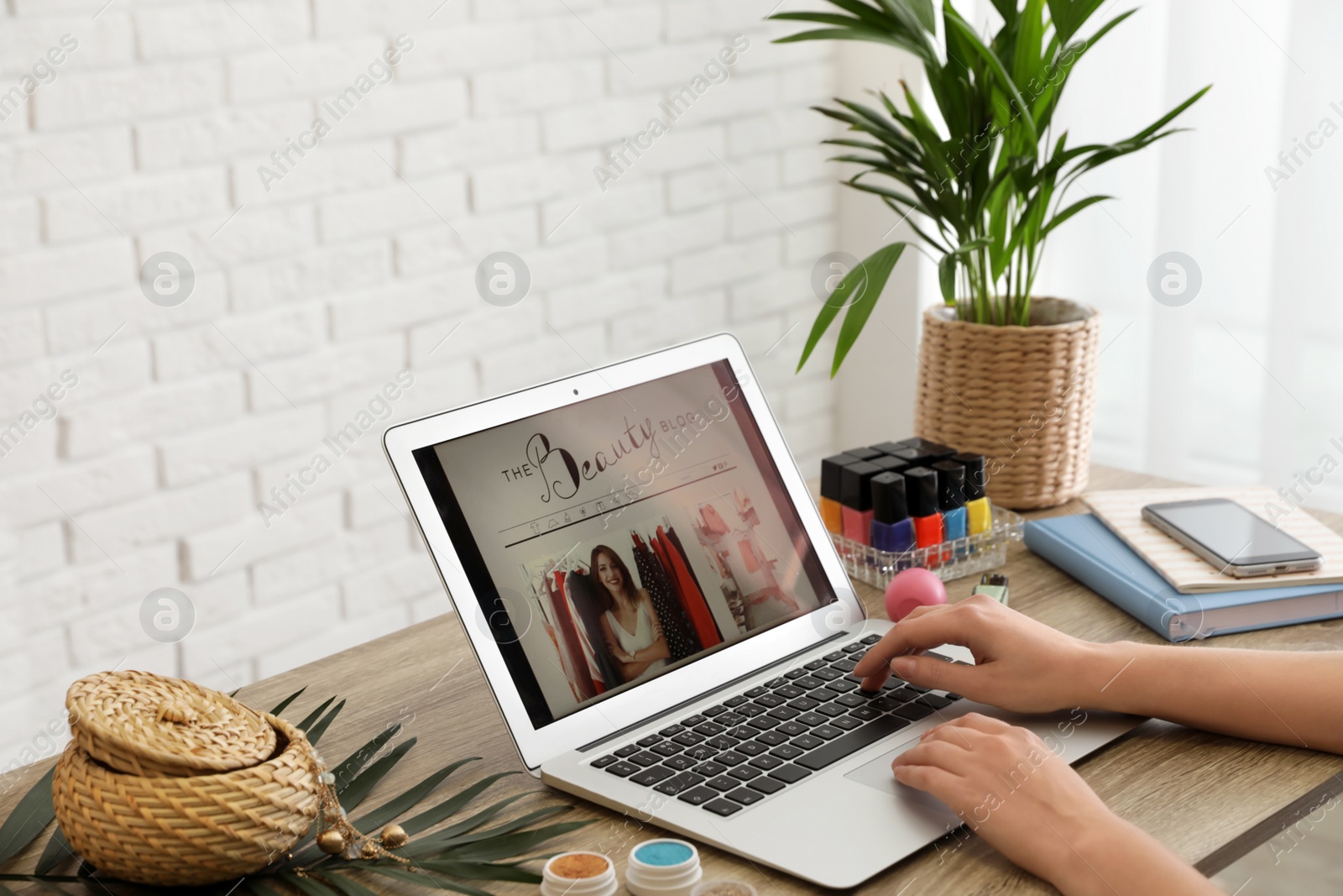 Photo of Woman working with beauty blogger site on laptop at table, closeup