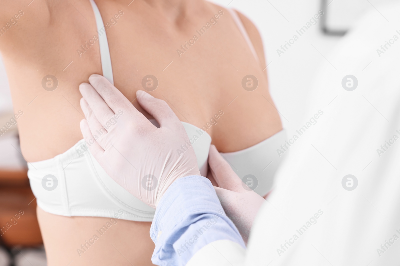 Photo of Mammologist checking woman's breast in hospital, closeup