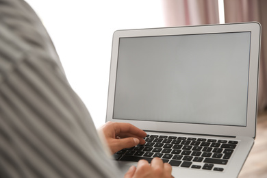 Photo of Woman working with modern laptop indoors, closeup. Space for design