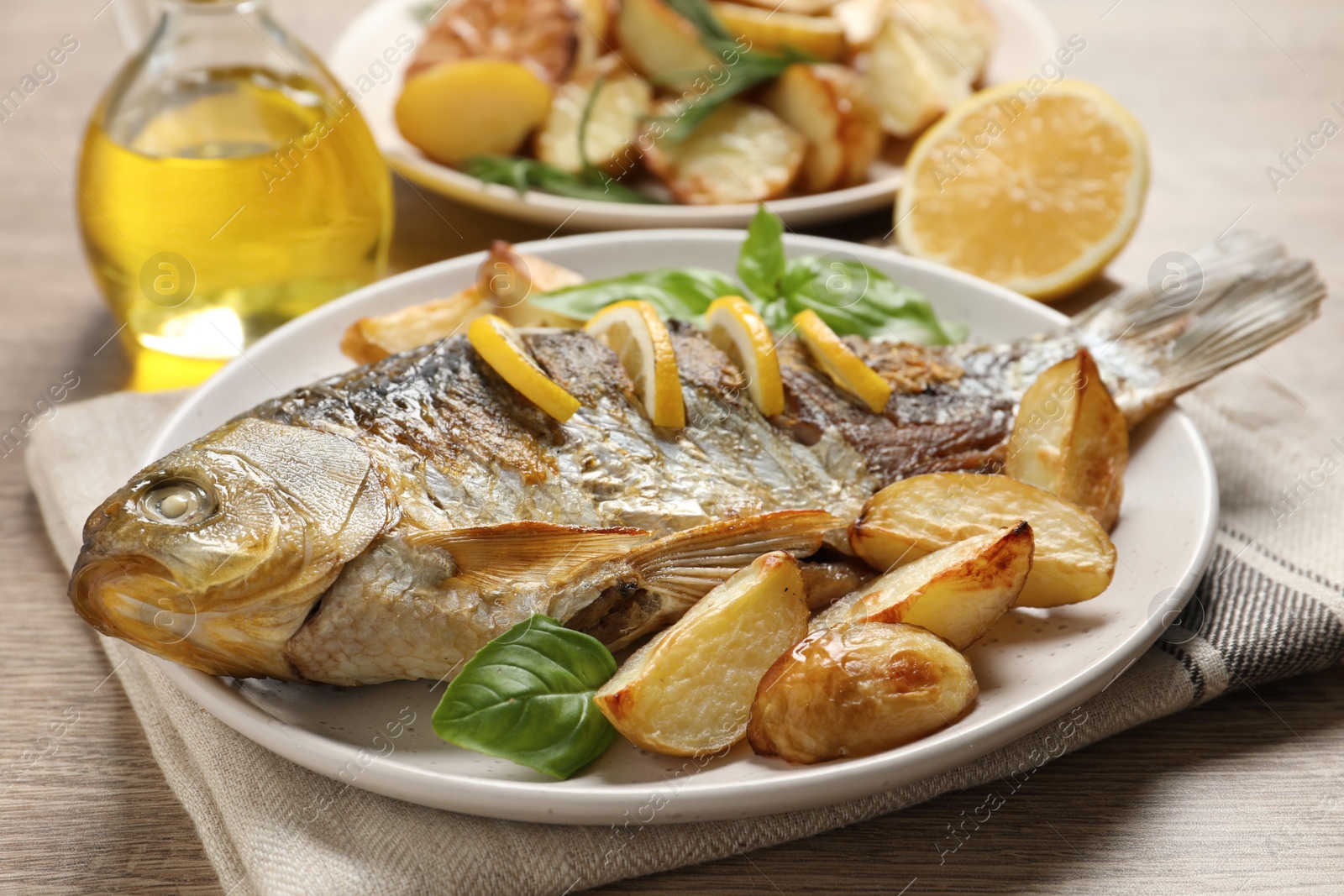 Photo of Tasty homemade roasted crucian carp served on wooden table. River fish