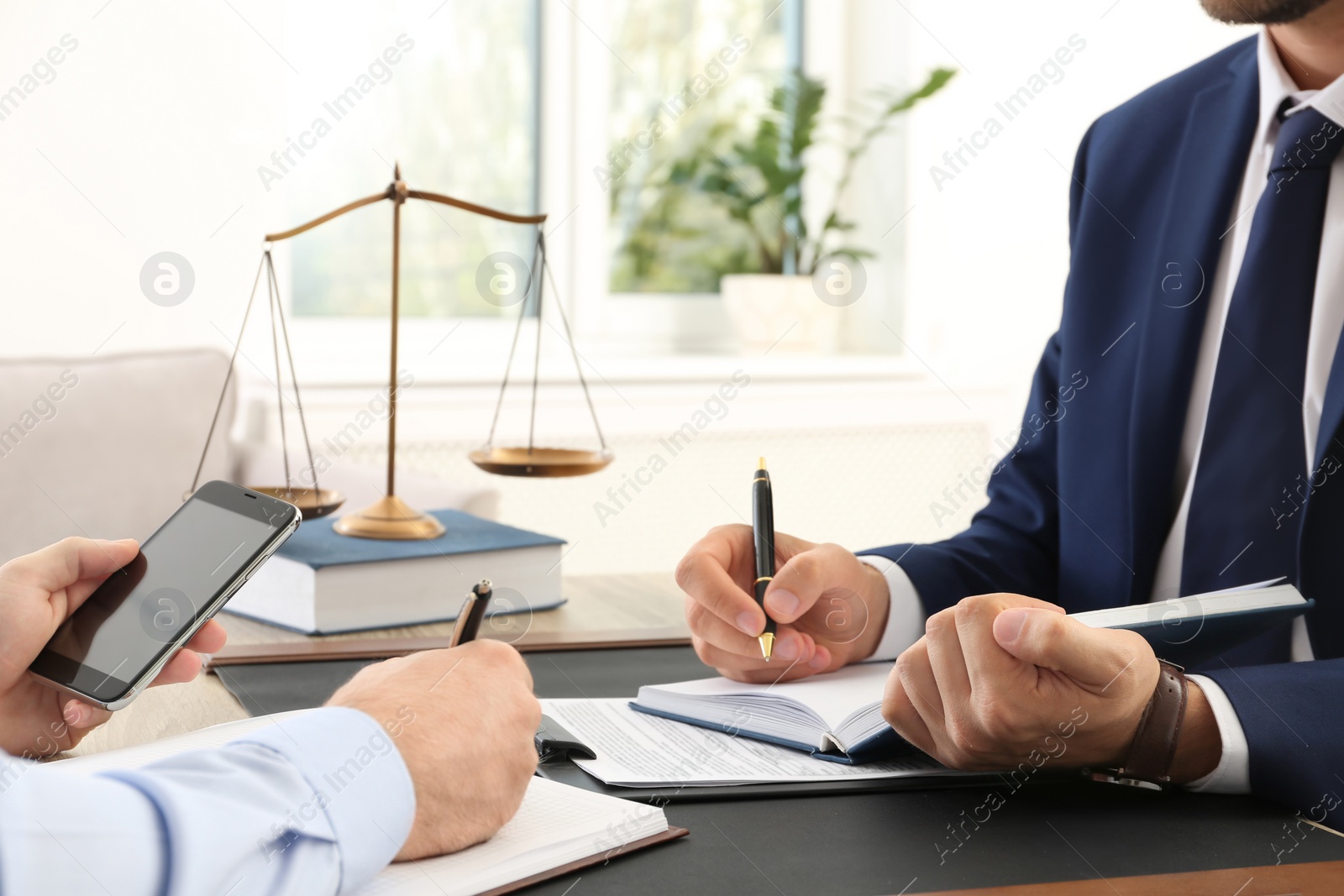 Photo of Lawyer working with client at table in office, focus on hands