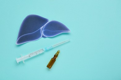 Photo of Paper liver, syringe and vial on turquoise background, flat lay with space for text. Hepatitis treatment
