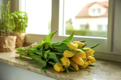 Photo of Bunch of beautiful yellow tulip flowers on windowsill