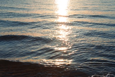 Photo of Rippled surface of sea at sunset as background