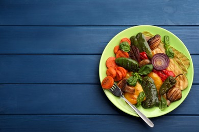 Photo of Delicious grilled vegetables on blue wooden table, top view. Space for text