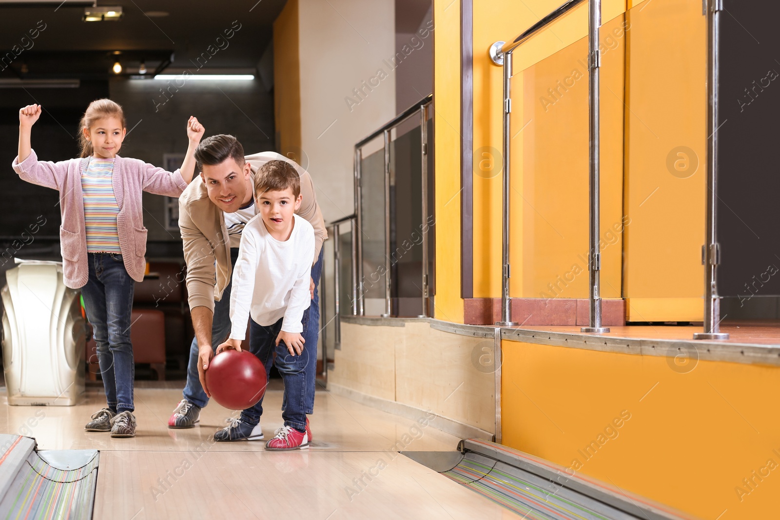 Photo of Happy family spending time together in bowling club