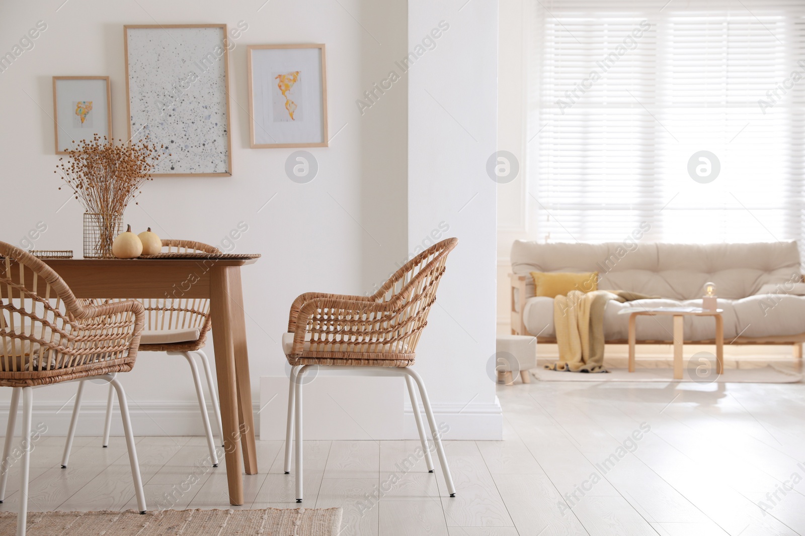 Photo of Dining room interior with wooden table and wicker chairs