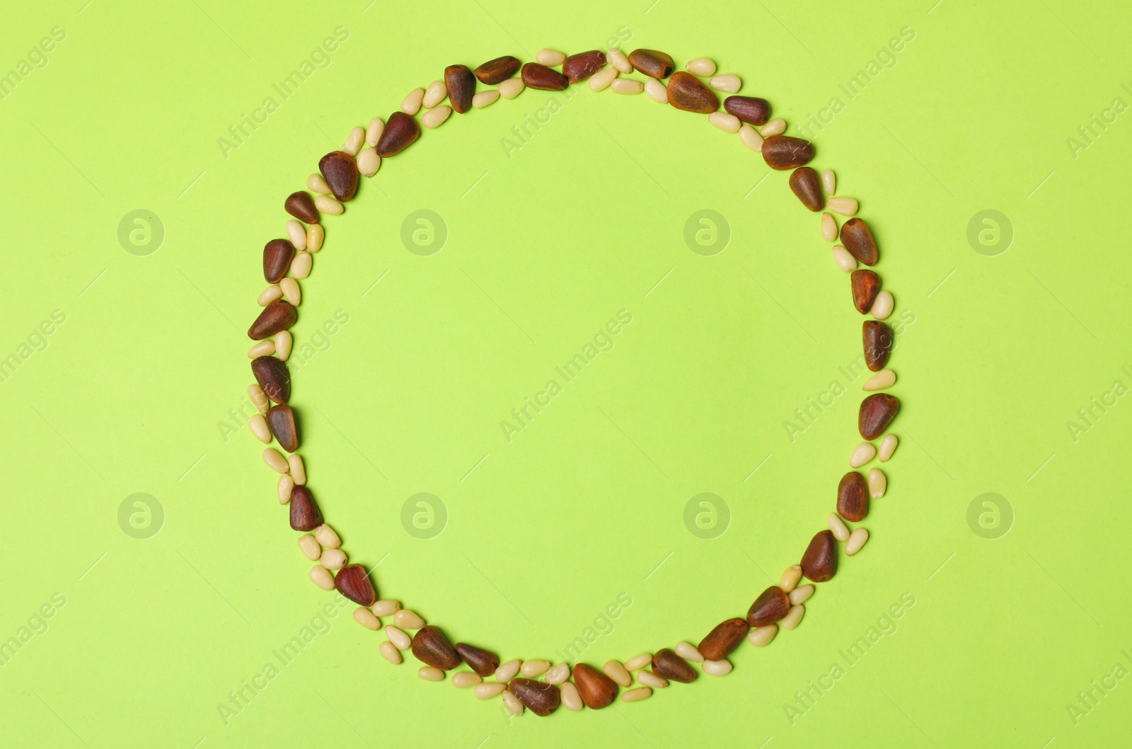 Photo of Frame made with pine nuts and space for text on color background, top view