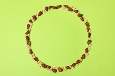 Photo of Frame made with pine nuts and space for text on color background, top view