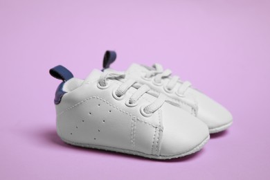 Pair of cute baby shoes on violet background