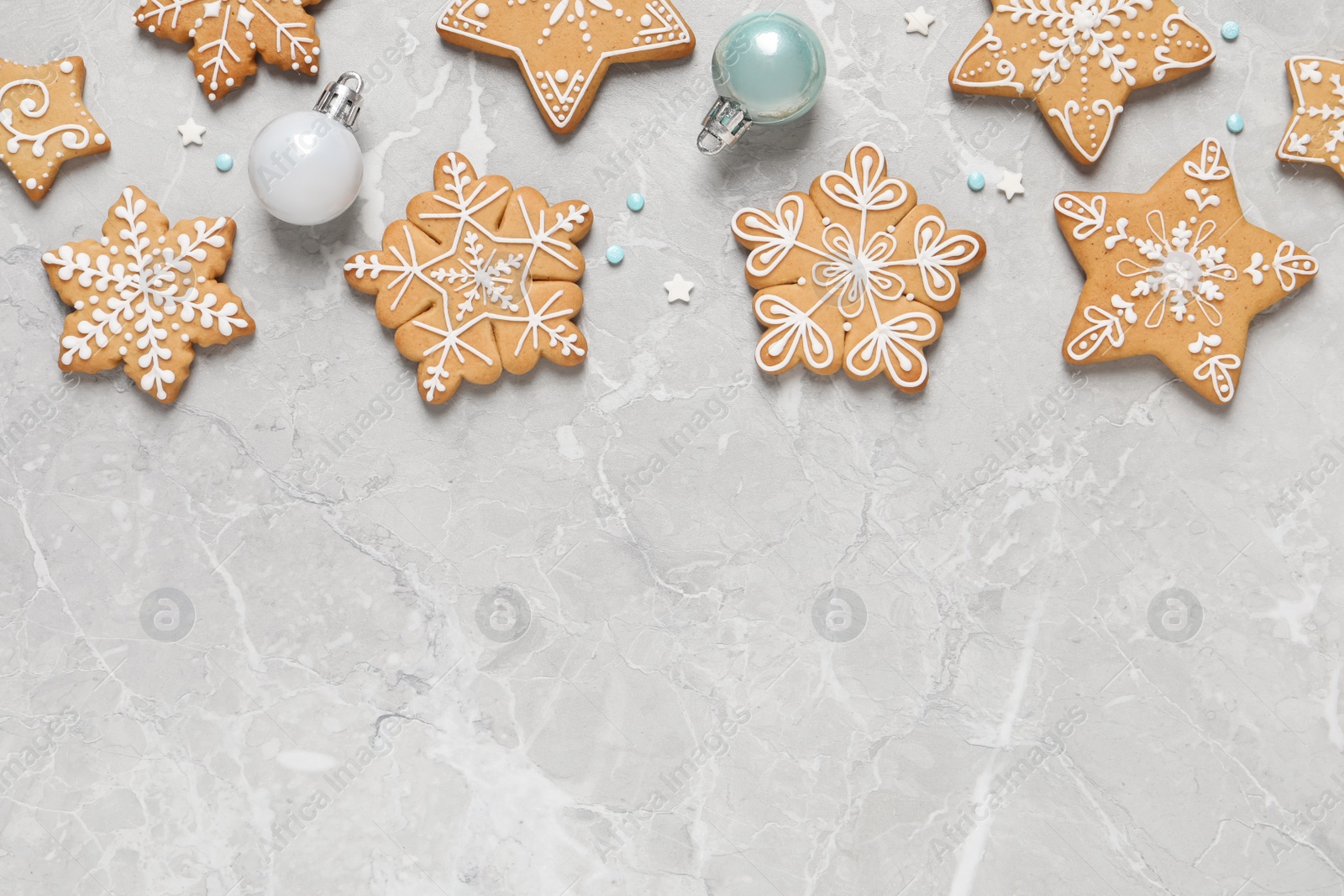 Photo of Tasty Christmas cookies and baubles on light grey marble table, flat lay. Space for text