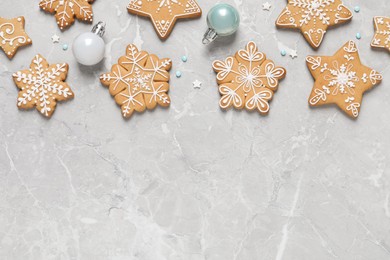 Photo of Tasty Christmas cookies and baubles on light grey marble table, flat lay. Space for text