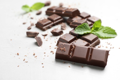 Pieces of dark chocolate with mint on gray table