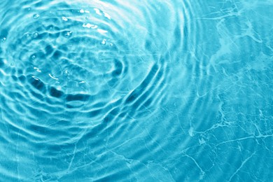 Image of Rippled surface of clear water on light blue background, top view