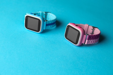 Photo of Modern trendy smart watches for kids on light blue background