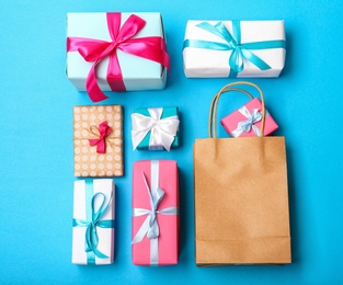 Flat lay composition with shopping bag and gifts on color background