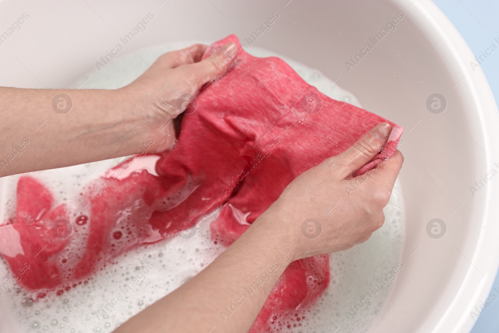Photo of Woman washing baby clothes in basin, closeup