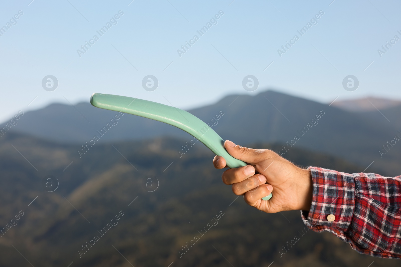 Photo of Man throwing boomerang in mountains, closeup view