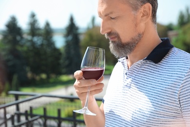 Photo of Man with glass of red wine outdoors