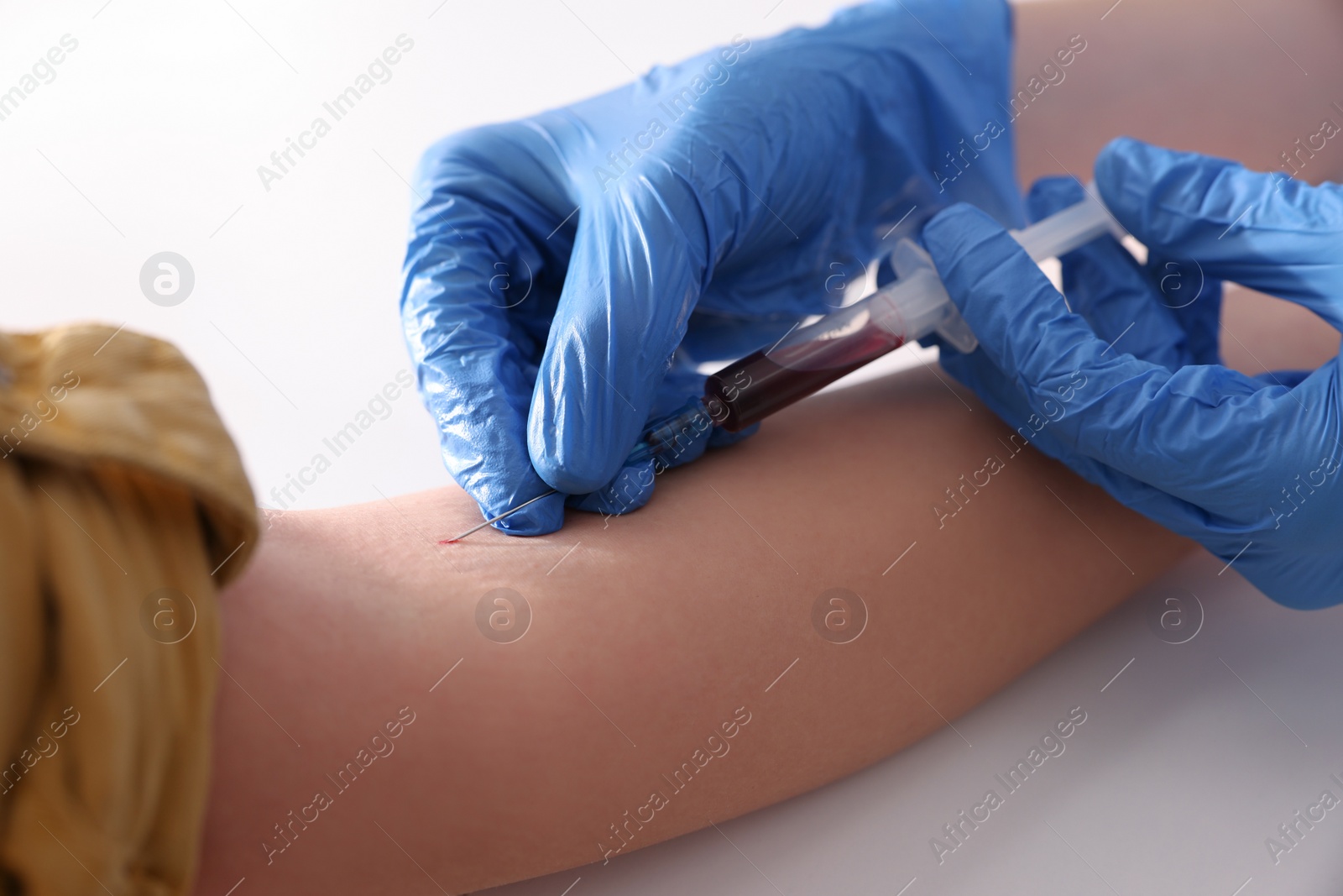 Photo of Doctor drawing blood sample of patient with syringe in hospital, closeup