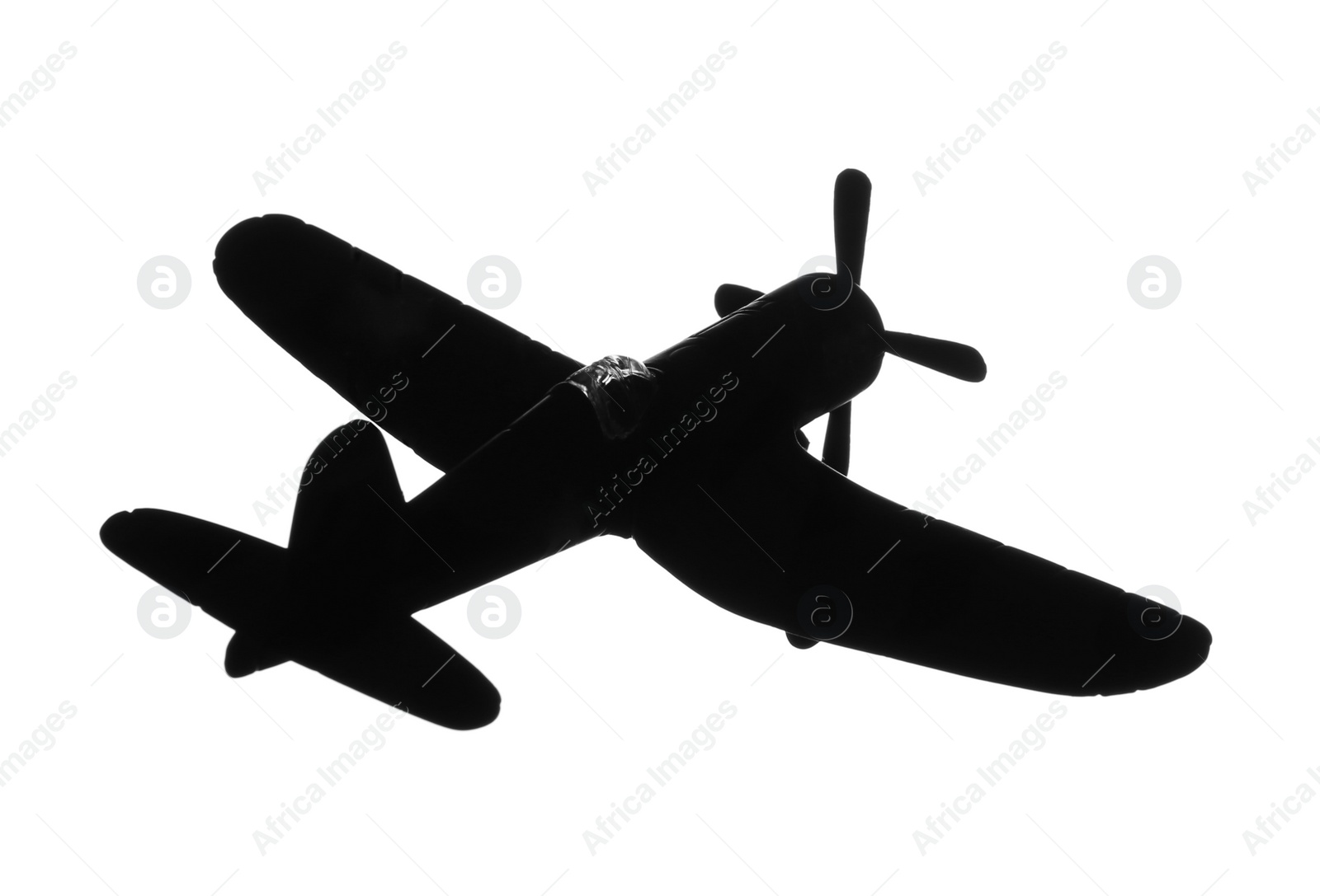 Photo of Dark silhouette of vintage toy military airplane on white background